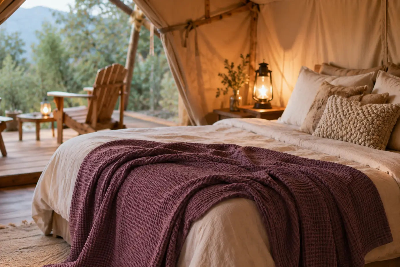 Burgundy linen blanket draped over a glamping bed in a cozy outdoor tent, showing how linen adds comfort to camping and glamping
