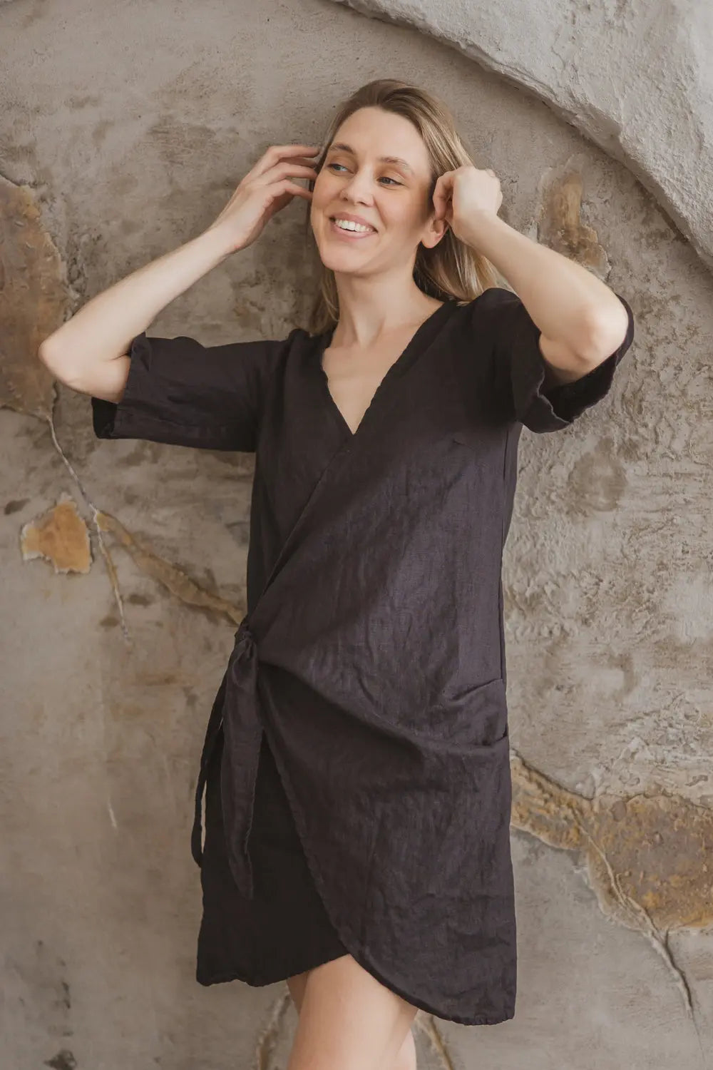 Side profile view of a lightweight linen wrap dress showing the flattering silhouette
