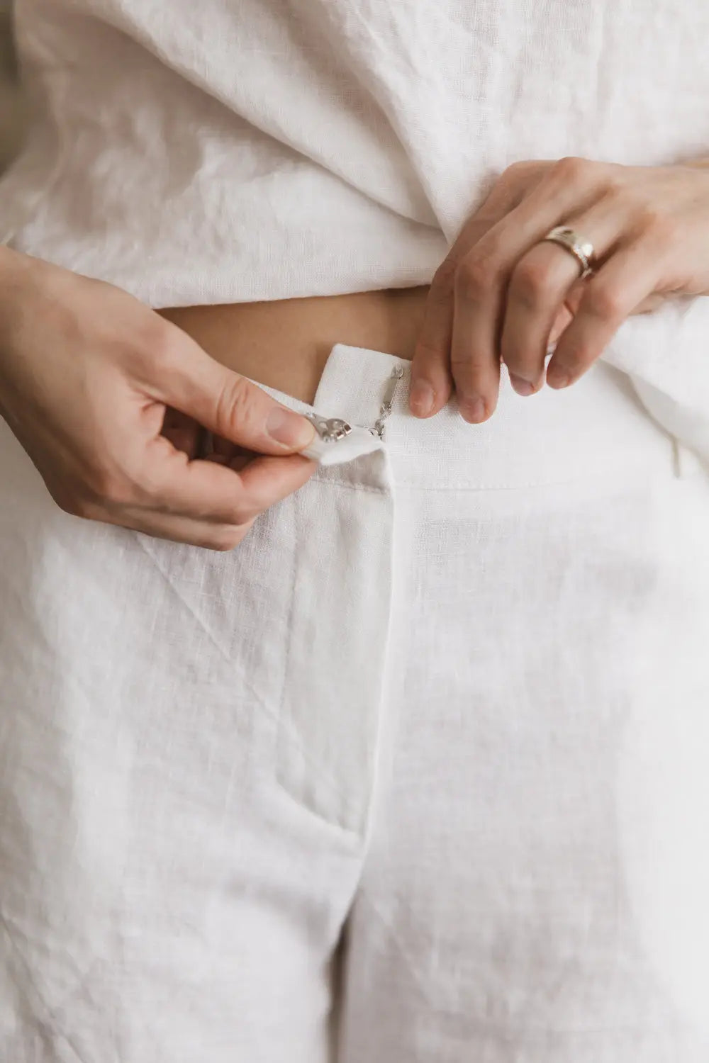 Close-up detail of high-waist closure on premium linen pants with hook closure