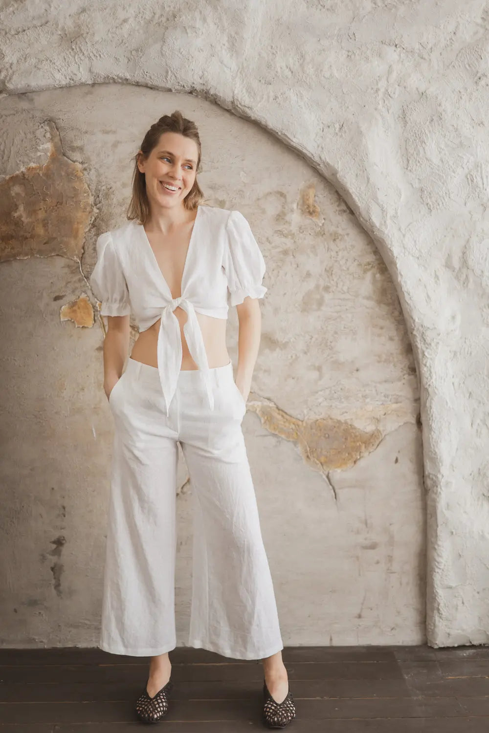 Linen tie-front crop top with puff sleeves paired with wide-leg linen trousers, full length view