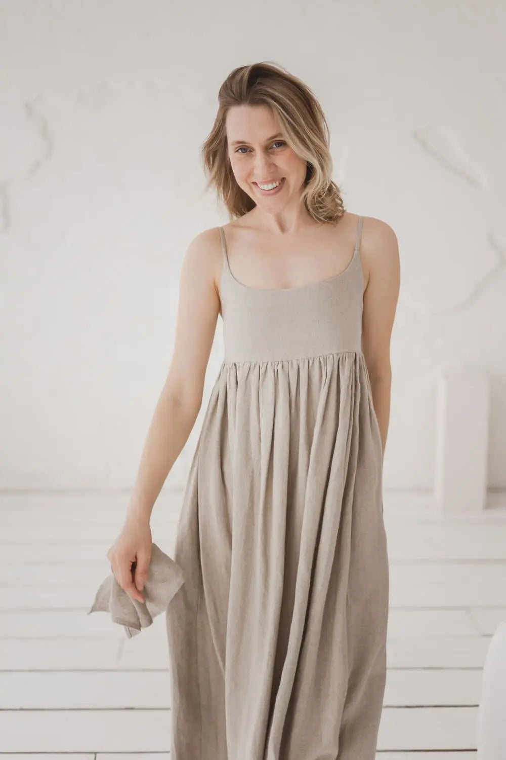 Model smiling in natural linen maxi dress with spaghetti straps, front view